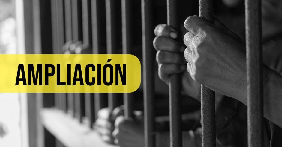 Manos de persona encerrada sobre los barrotes de la cárcel.