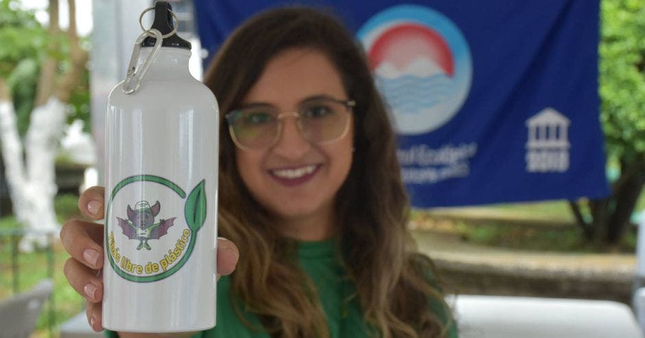 Una mujers sostiene una botella con la publicidad de Tibás libre de plástico