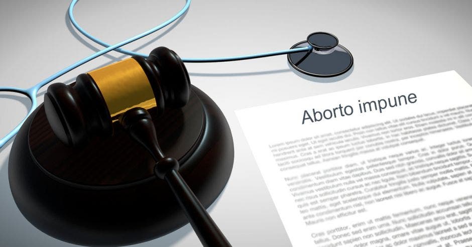 Un papel que dice aborto impune, un estetoscopio y un mazo de abogado