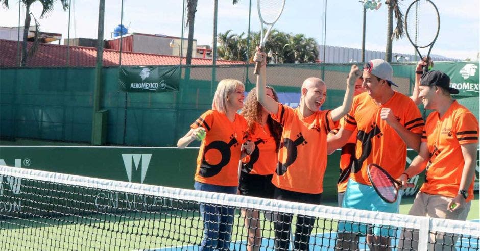 jóvenes con raquetas en cancha de tenis