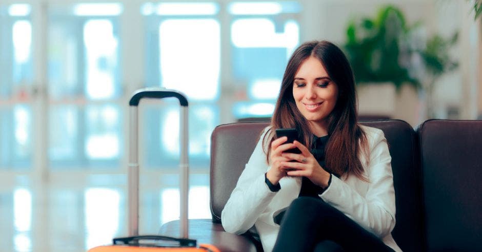 Mujer revisando celular antes de viajar