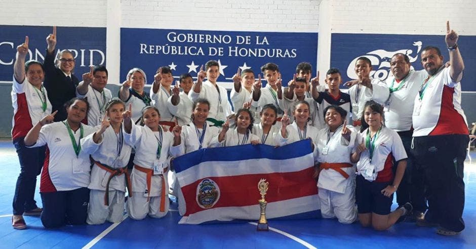 niños de jufo con bandera medallas y trofeo