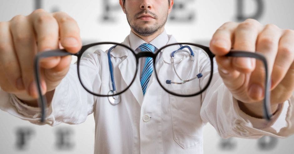 Un médico sosteniendo unos lentes