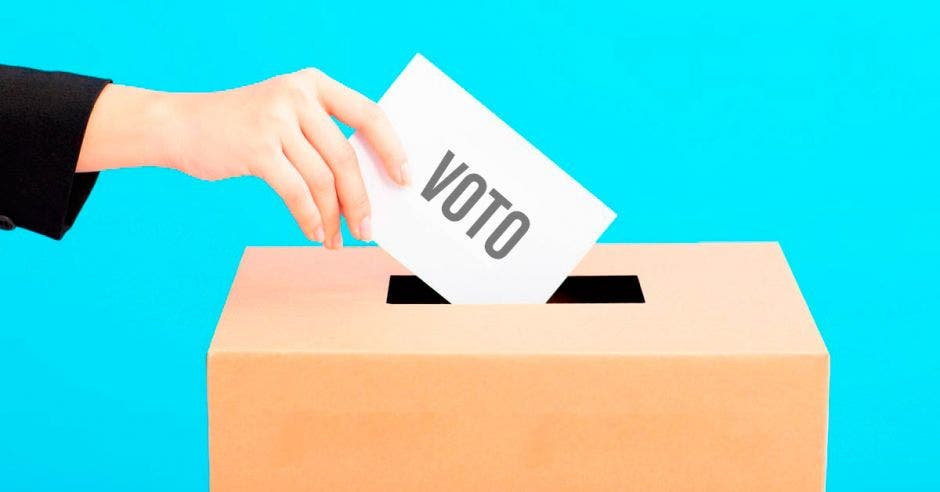 Una dama depositando su voto en la caja de votación