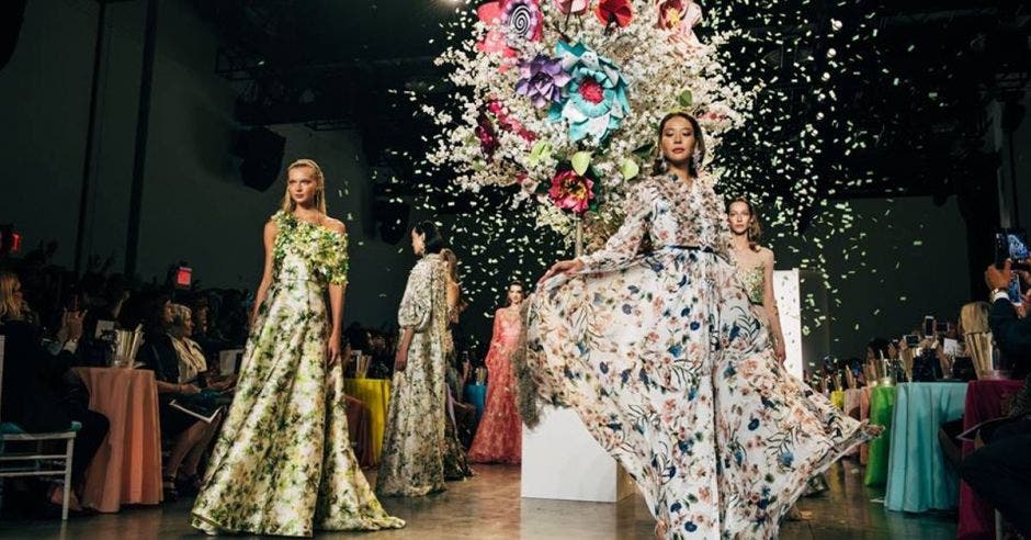 Dos modelos de la pasarela con unos vestido floreados, con una explosión de flores en medio, parte del desfile
