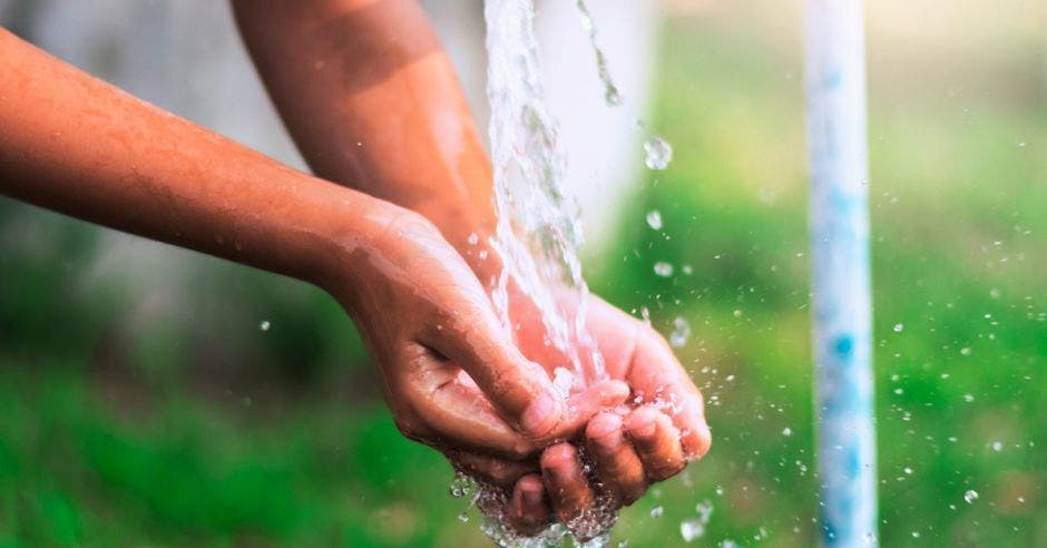 Alguien toma agua de una fuente