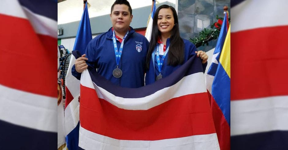 hombre y mujer posan con bandera de costa rica