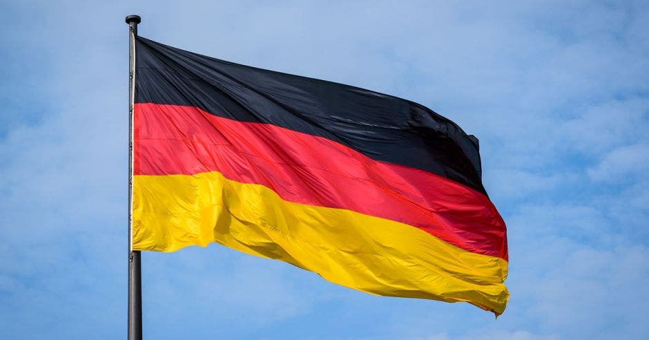 Una bandera de Alemania ondea en el cielo color claro