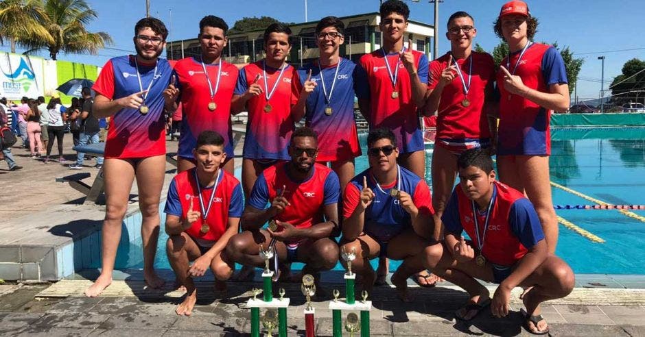 hombres en piscina celebran con trofeo