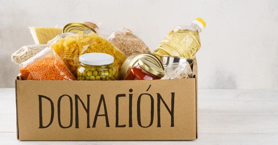 caja de cartón con la palabra donación llena de alimentos variados