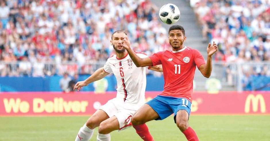 Johan Venegas disputa un balón frente a un jugador de Serbia, en el Mundial