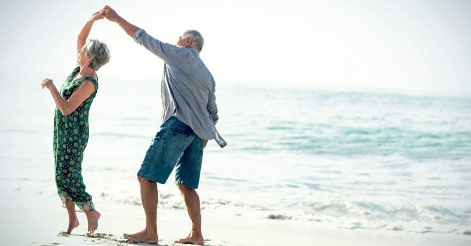 Una pareja de adultos mayores baila en la playa