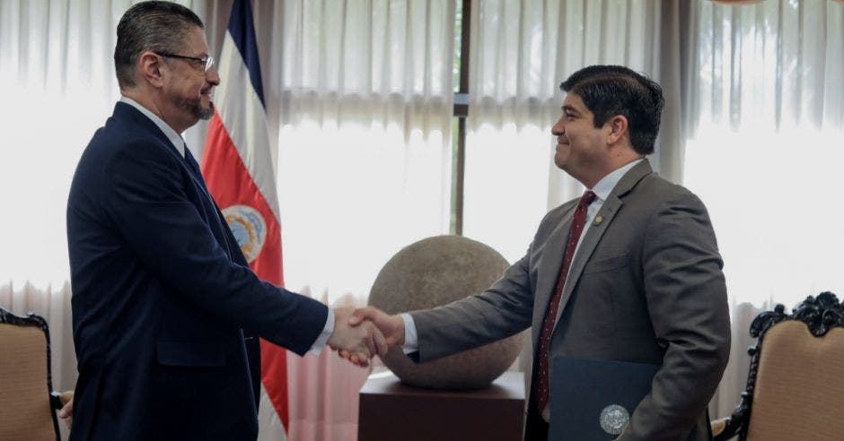 Carlos alvarado le da la mano al nuevo ministro de hacienda.