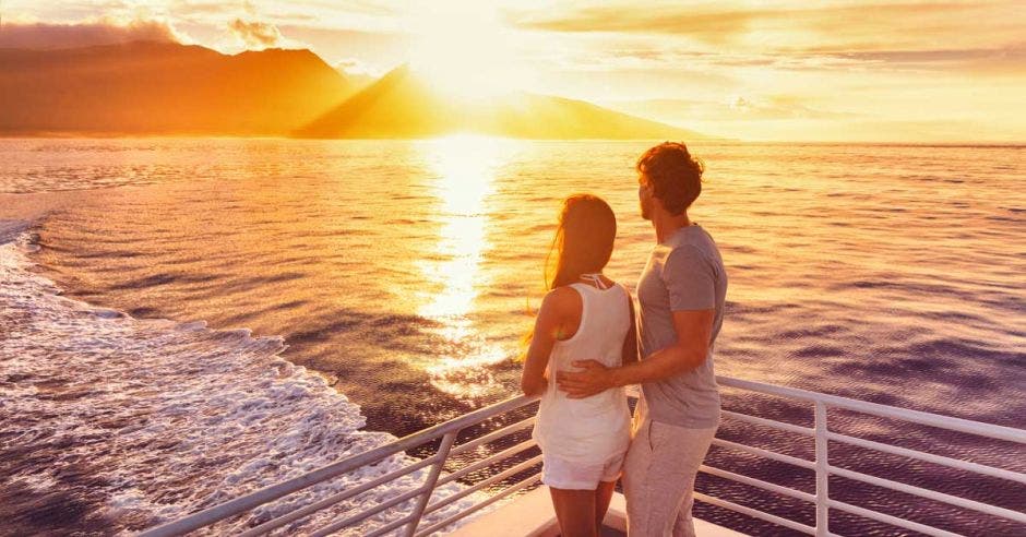 Una pareja disfruta de la puesta de sol a bordo de un crucero