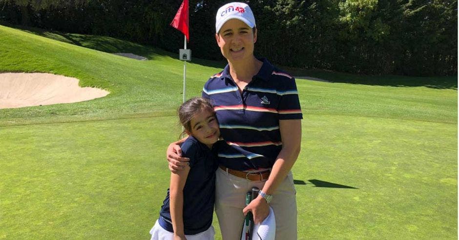 niña y mujer posan en golf