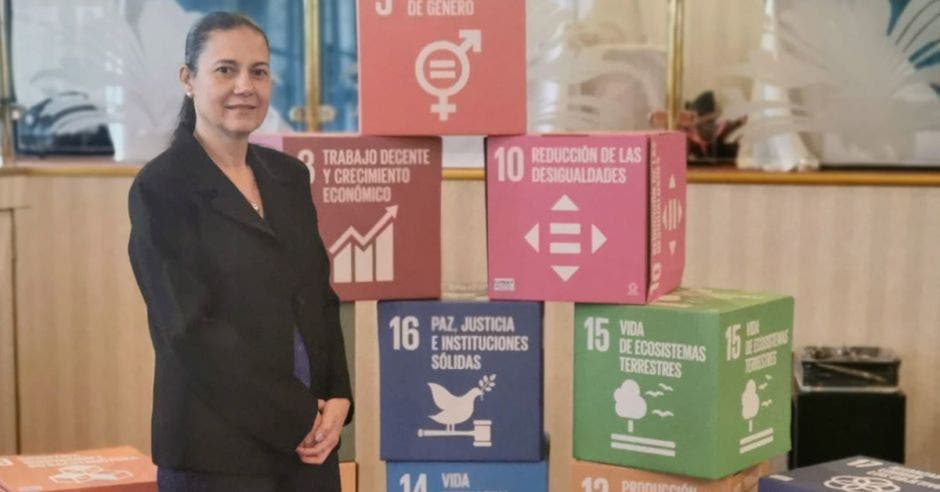 mujer posa con cajas de colores de fondo