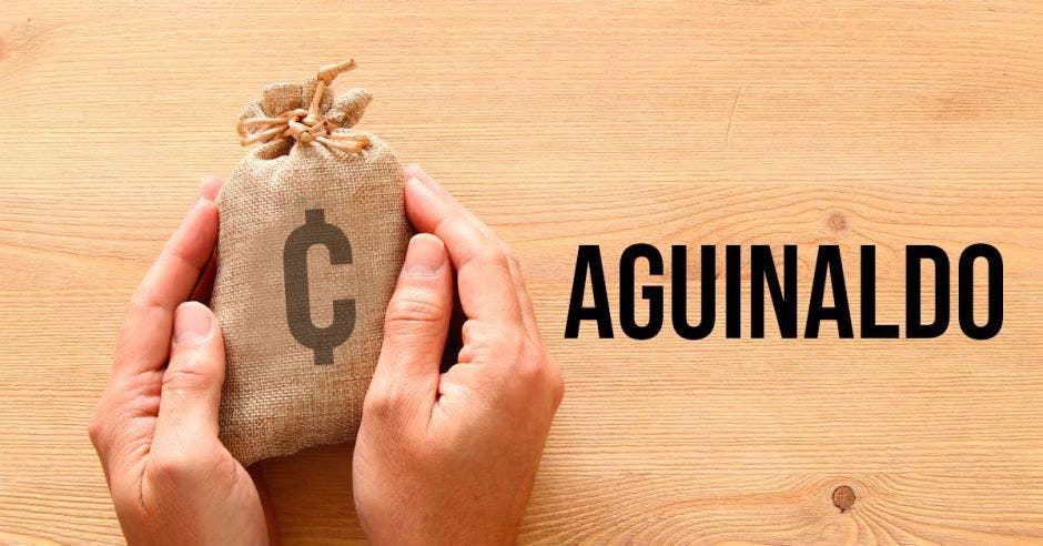 Mano sostiene una pequeña bolsa con el signo de colones que representa su aguinaldo