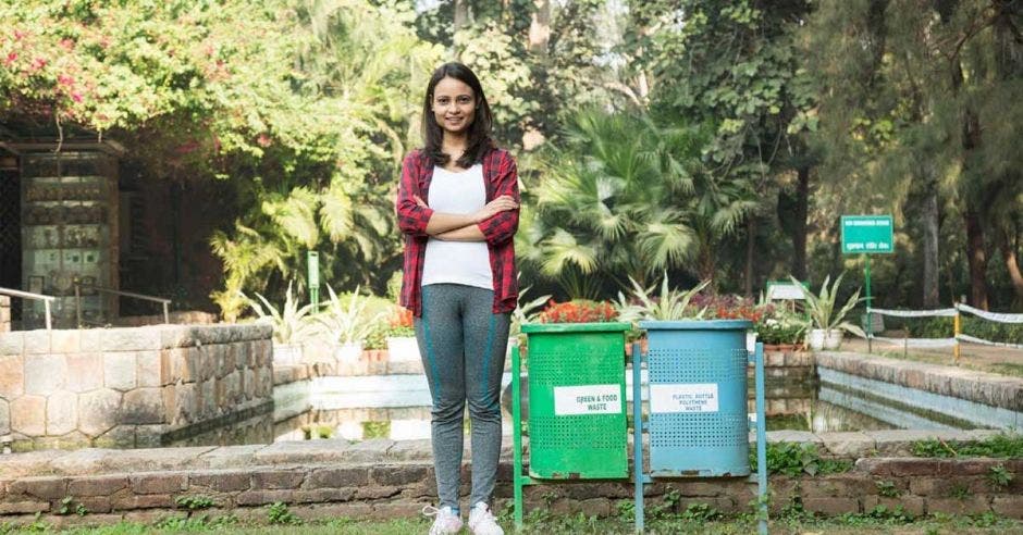 Una mujer posa junto a dos potes reciclaje