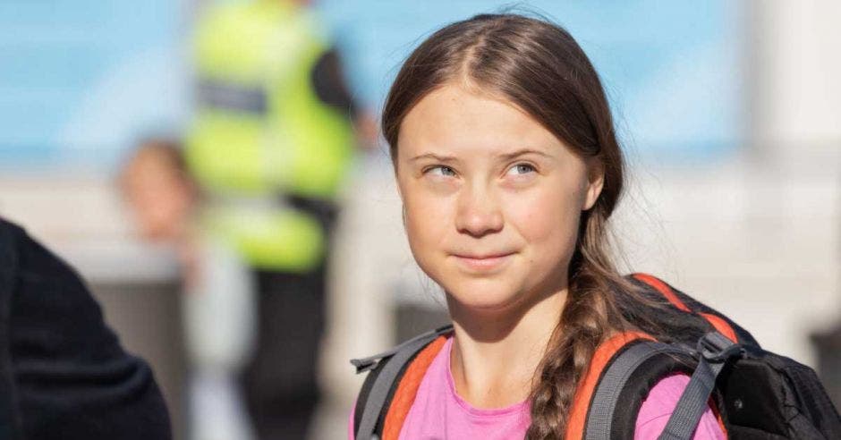 Greta Thunberg con una blusa rosada y un salveque color anaranjado