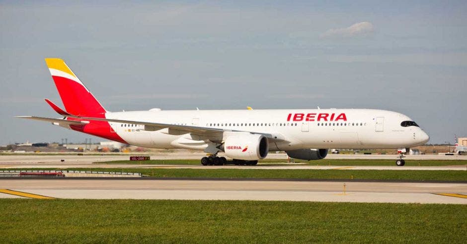 Un Airbus A350 color blanco con rojo en una pista de aterrizaje