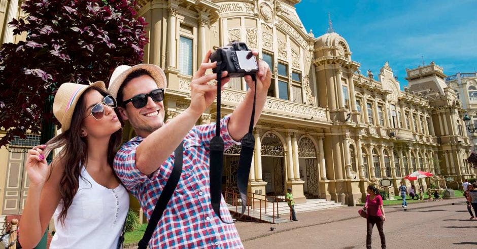 foto de dos jóvenes tomándose un selfie frente a correos de Costa Rica