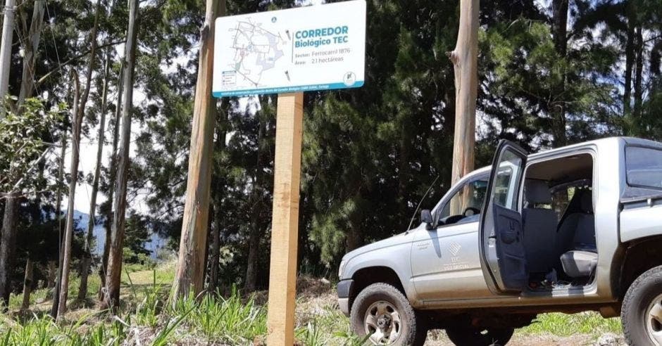 Un letrero y un carro del TEC color blanco