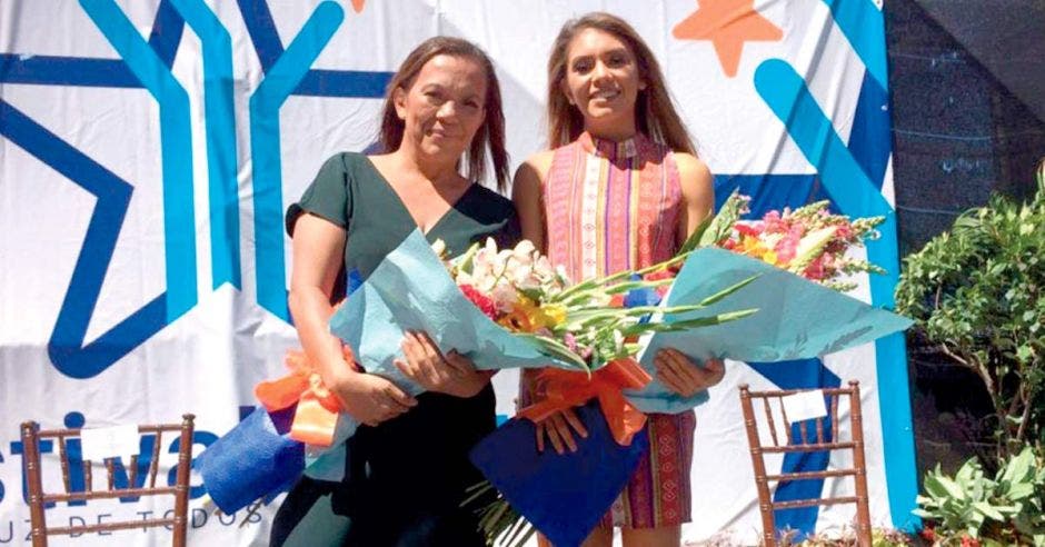 Dixinia junto a su hija Noelia Vargas con dos ramos de flores en el acto previo al festival de la luz