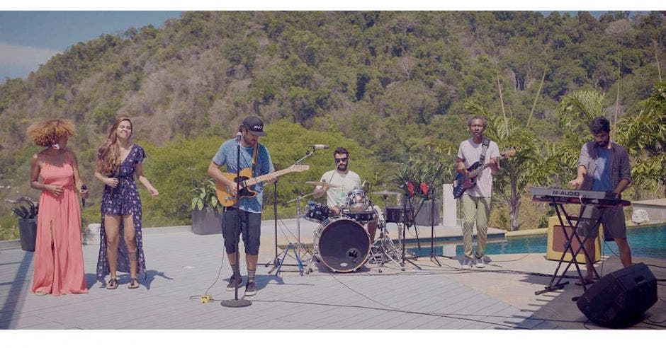 El grupo Earthstrong en una playa con toda su banda tocando uno de sus éxitos