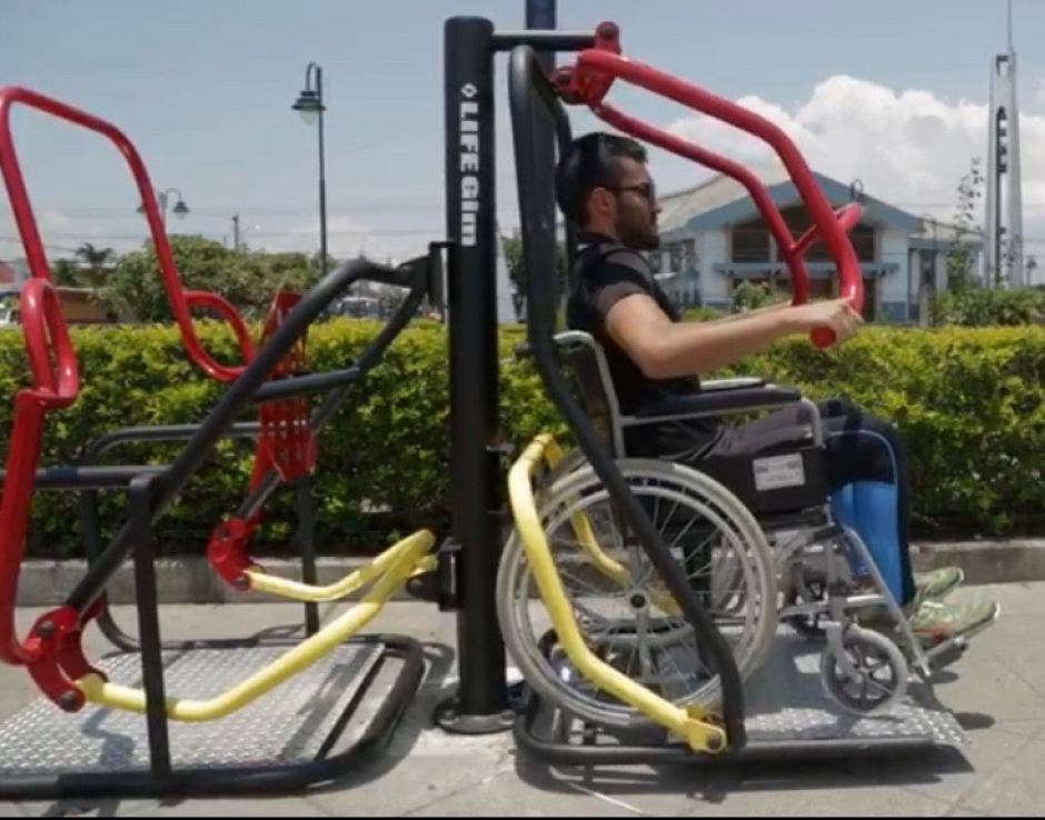 Joven en silla de ruedas haciendo ejercicio en un parque público