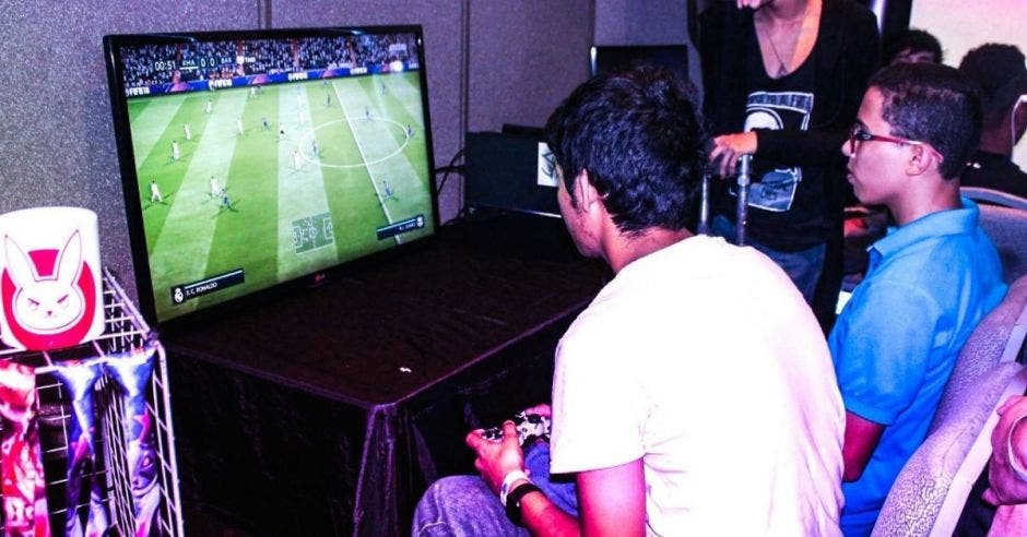 Dos jóvenes juegan un videojuego de fútbol