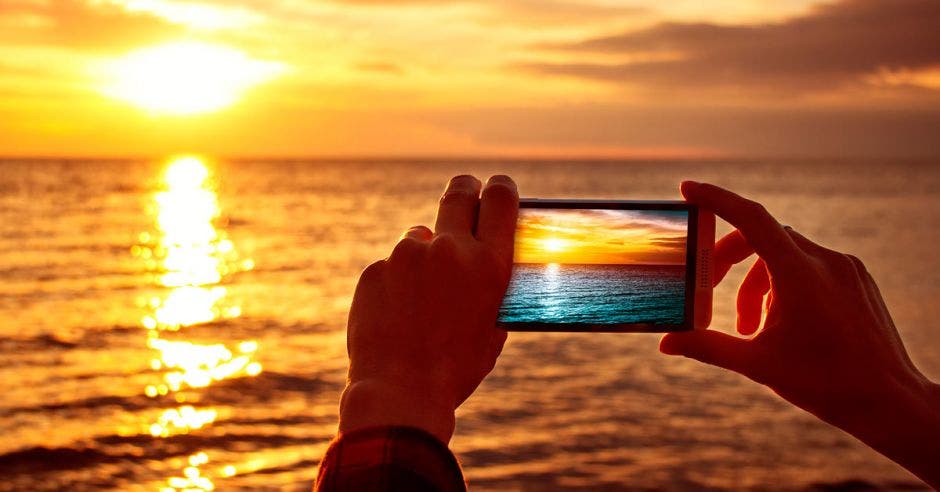 Alguien fotografía la puesta de sol en el horizonte