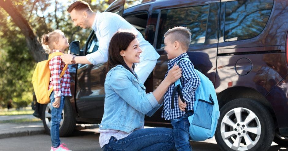 Familia deja a sus hijos a la escuela