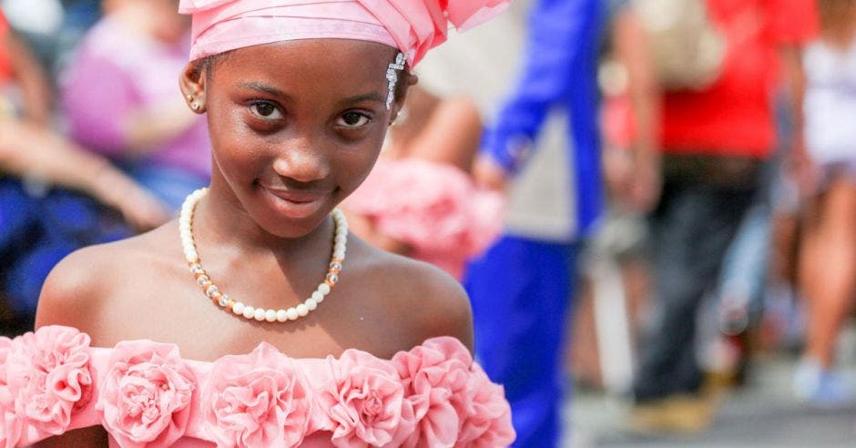 Una niña afrodescendiente con un vestido de color rosado, en una actividad cultural