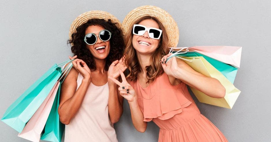 Dos mujeres de compras, con lentes negros y vestimentas de verano blanco y rosado