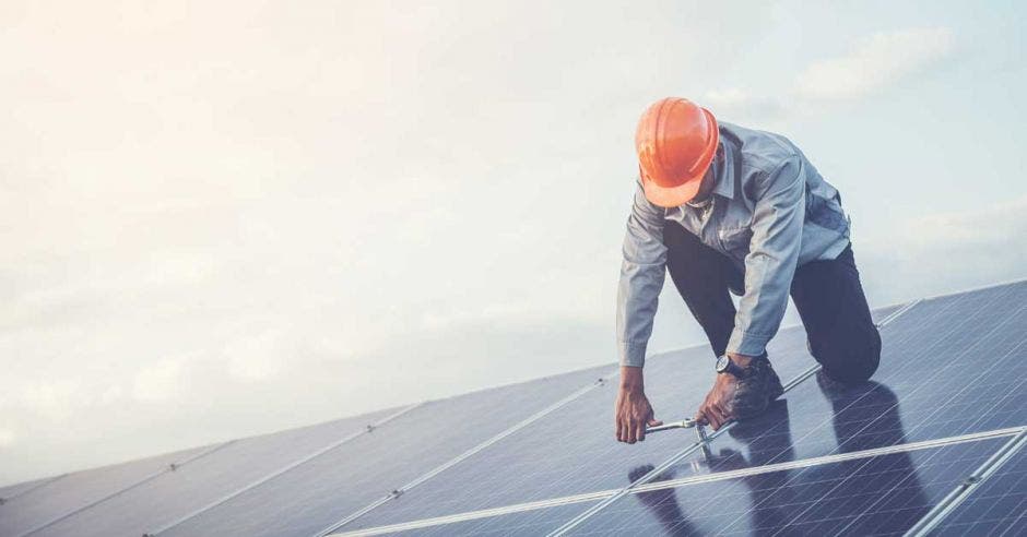 Un señor de mediana edad instala paneles solares