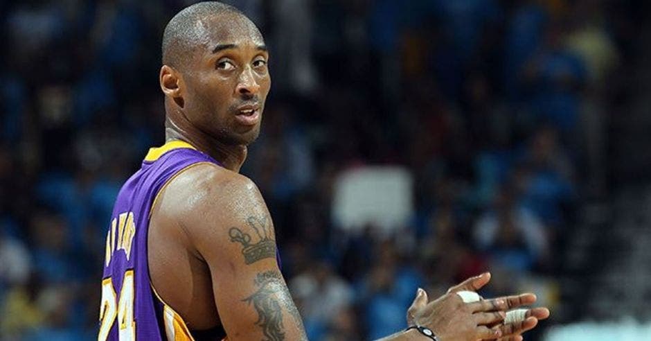 Kobe Bryant con uniforme morado de los Lakers, aplaudiendo en un partido cuando era jugador
