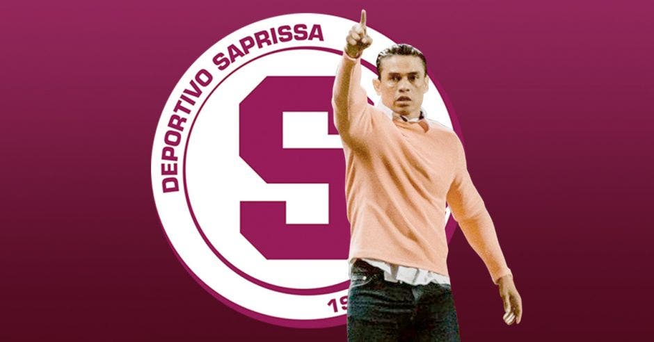 El técnico Centeno señalando hacia adelante con el logo de saprissa de fondo