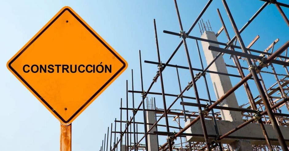 letrero con la palabra construcción, con un edificio en desarrollo detrás