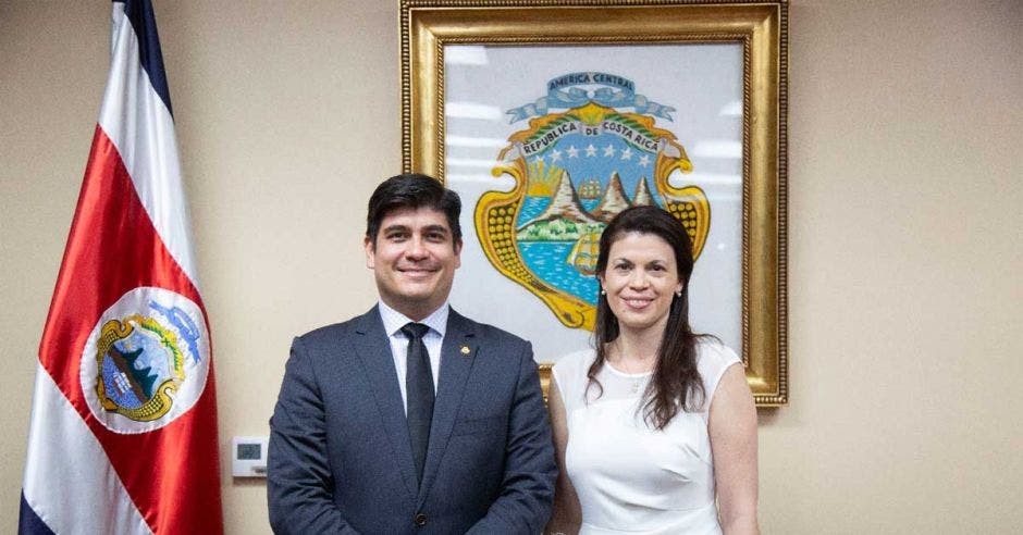 un hombre contextura gruesa de pie junto a una mujer trigueña en vestido blanco