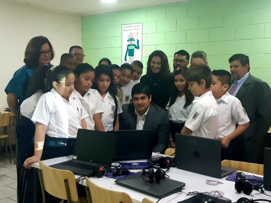 Unos niños viendo al Presidente usar una computadora