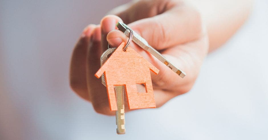 persona con unas llaves en la mano con un llavero en forma de casa