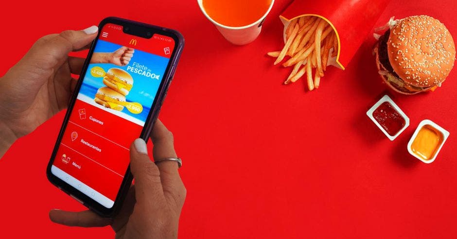 Una persona sostiene un celular con la app de Mcdonalds desplegada