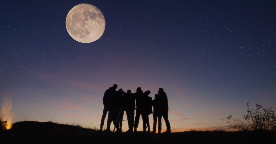 grupo de personas apreciando la luna