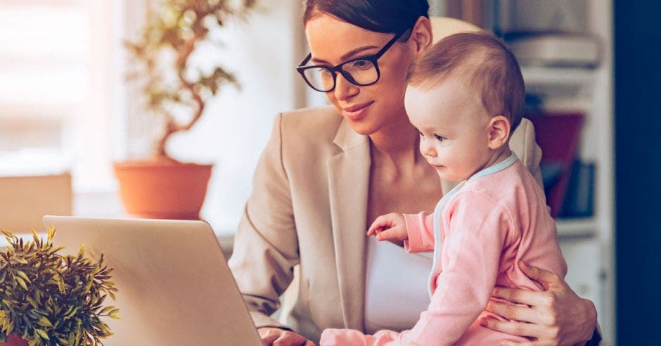 madre trabajando con su bebé frente a una computadora