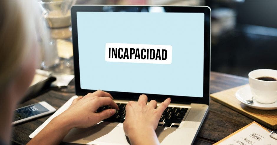 Una computadora y unas manos con la palabra incapacidad