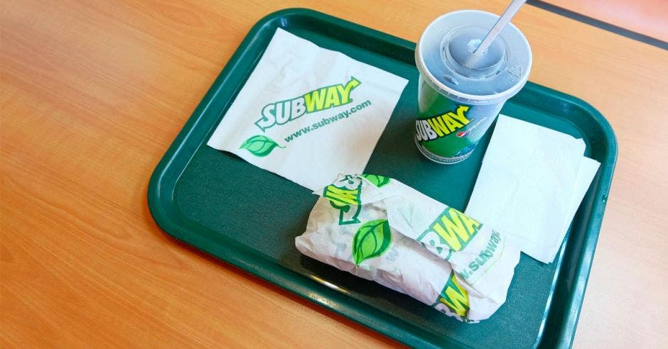 Una bandeja de subway con un vaso de gaseosa y un sándwich