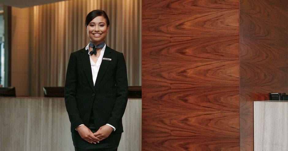 Una mujer de piel oscura posa en el lobby de un hotel