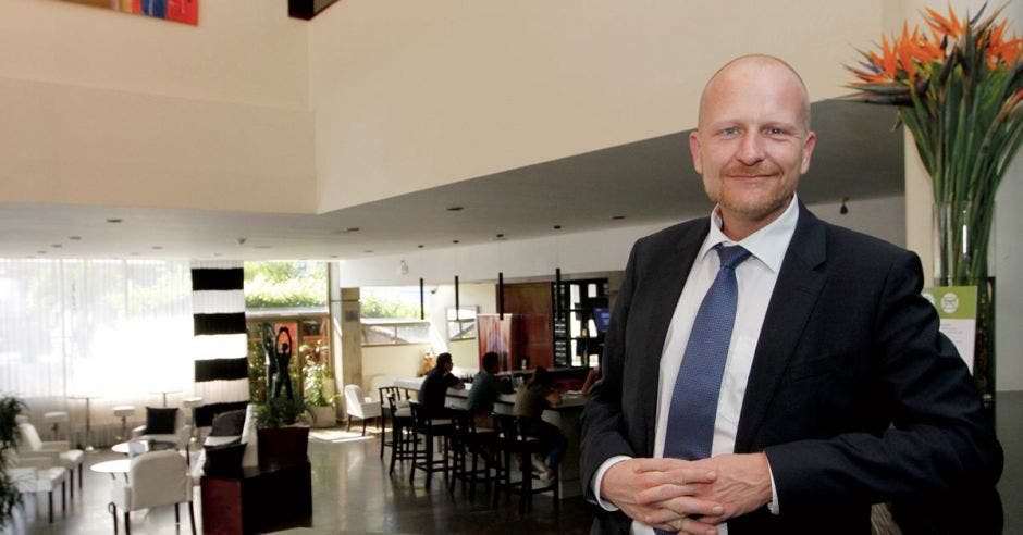 Un señor calvo sonríe en el lobby de un hotel