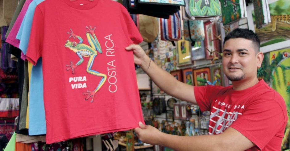 Un muchacho con camisa roja muestra una camisa