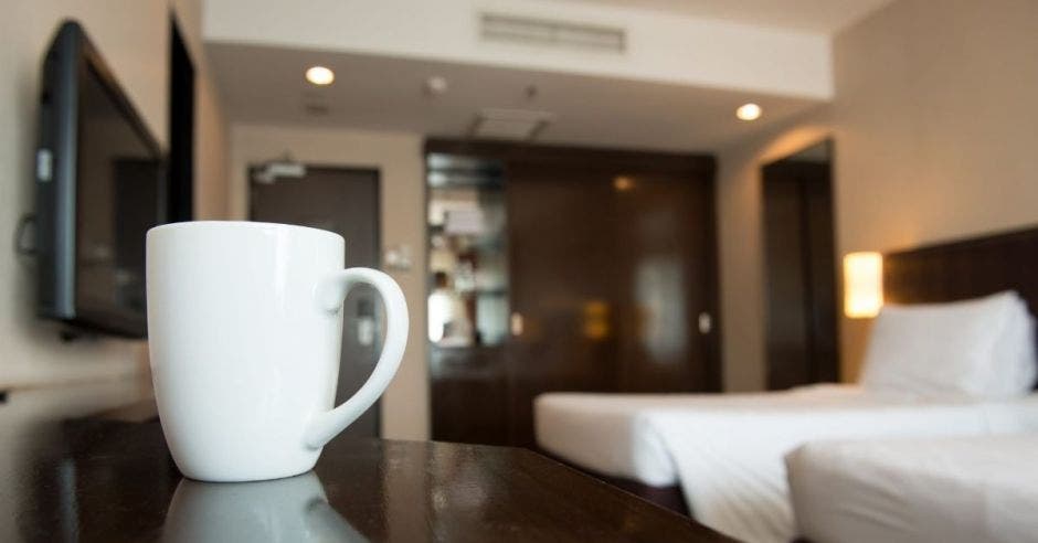 Una taza sobre una repisa en una habitación de hotel